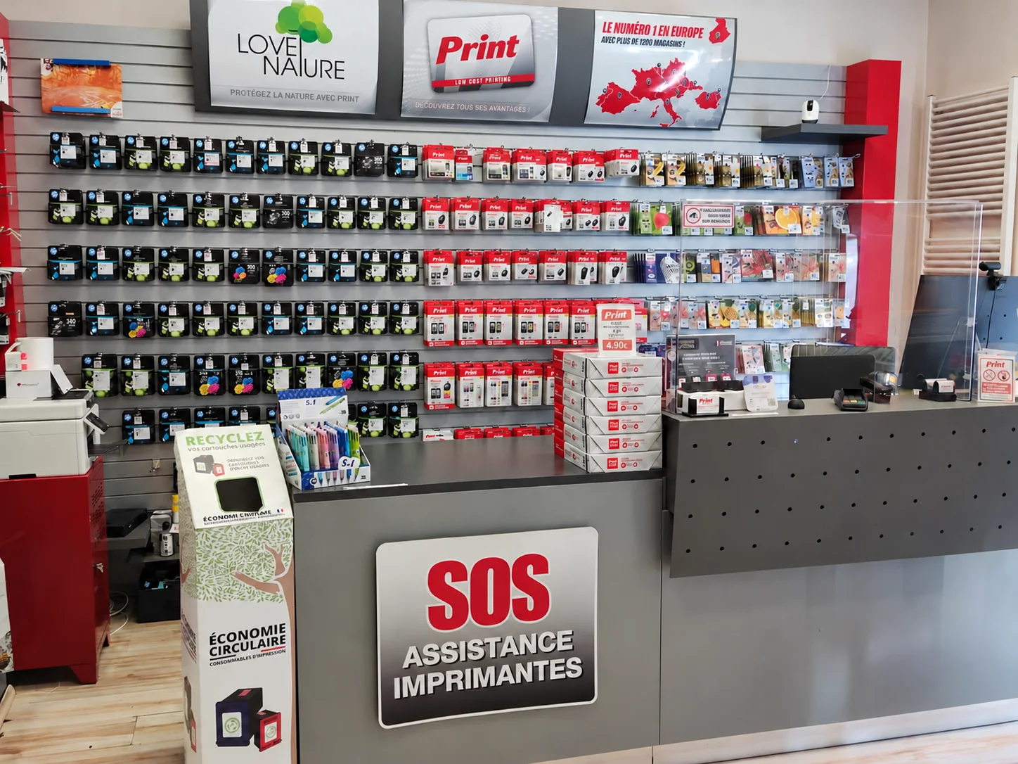 Comptoir du magasin Print’ Neudorf, mur de cartouches et espace SOS imprimantes